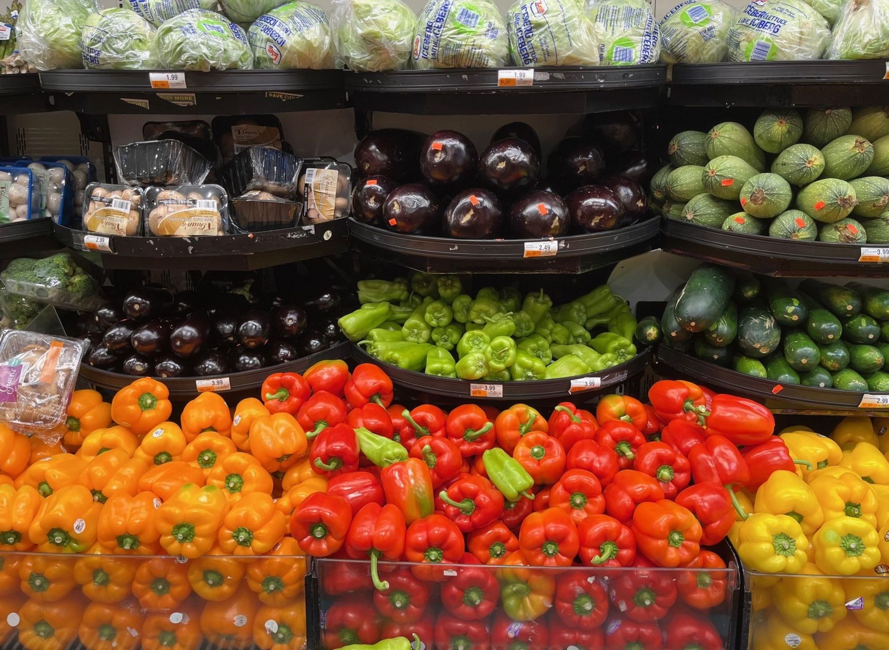 Expositor de verduras y hortalizas frescas con precios en la sección de frutería de un supermercado